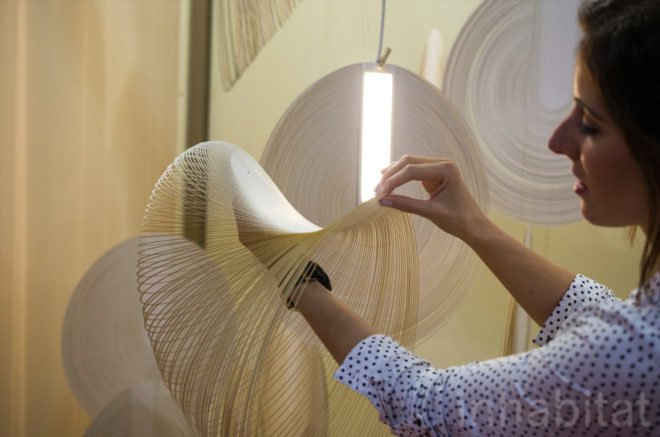 Woman touches the OLED panel inside the Sila lamp.