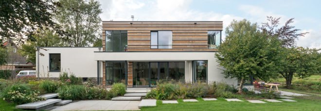 Image of the exterior of the home shows its large windows, designed to let in plenty of natural light.