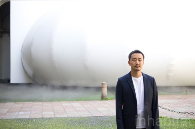 Takehiro Ikeda stands outside the installment.