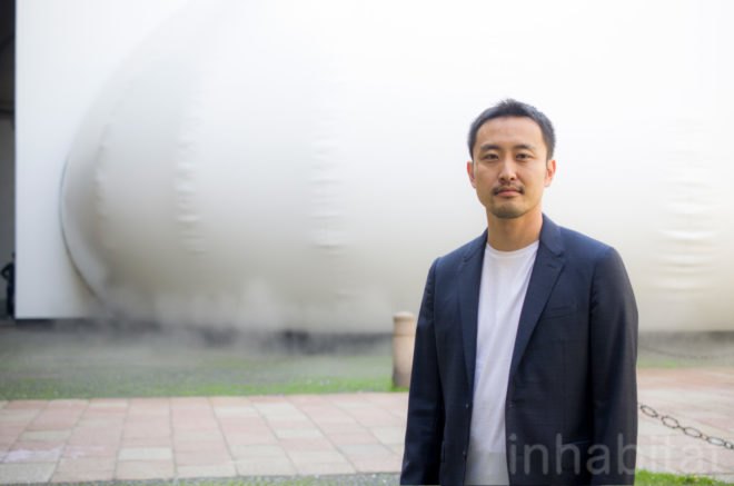 Takehiro Ikeda stands outside the installment.