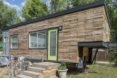 A tiny home with wooden siding and a bright green door.