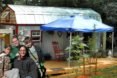 Karl and Hari Berzins and their two children stand outside the tiny home they built using salvaged materials.
