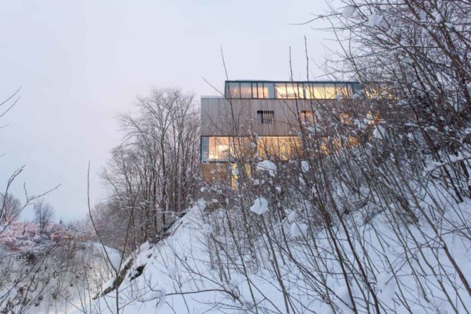 “The main task was for the project to appear as a unify house despite its duality, and still ensure the privacy of both units,” wrote the architects. “The ground floor integrates the main public functions of the homes and elegant windows frame the landscape scenery and invite nature into the building. On the contrary, the first floor protects the intimacy of the families and provides a more introvert area, with windows subtly appearing behind the cedar cladding.” Privacy is retained despite ample glazing Two-in-One House by Reiulf Ramstad Arkitekter
