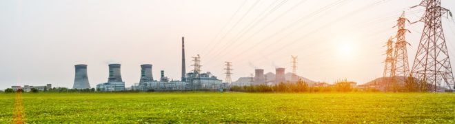 A power station photographed at sunset with power lines