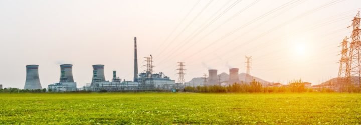 A power station photographed at sunset with power lines