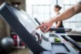 Person pressing buttons on the treadmill.