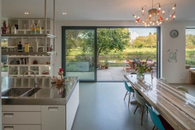 Large glass windows and patio doors provide plenty of natural light in the kitchen and dining space.
