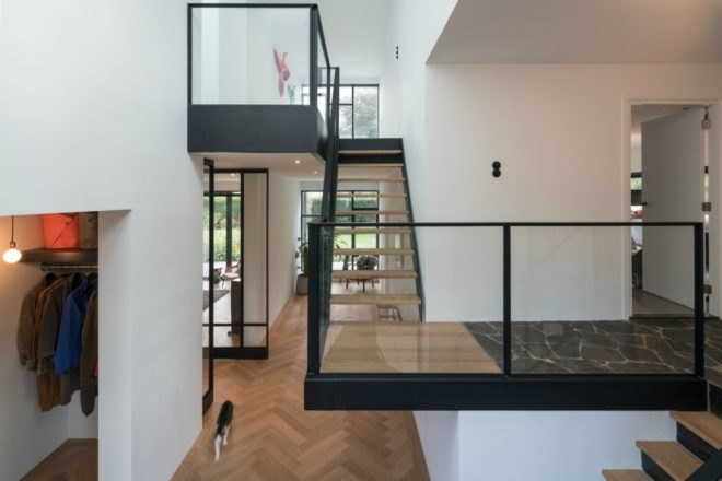 The staircase has wooden steps and glass railings to make the space appear even more open.