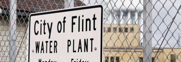 Black and white sign on a fence reads 
