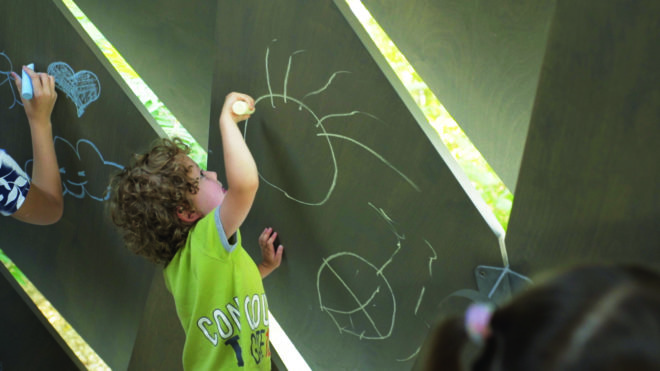 child drawing on gazebo with chalk