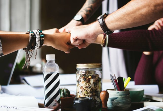 A few people are "fist bumping" or hitting their knuckles together.