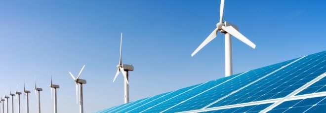 Wind turbines and solar panels against a blue sky