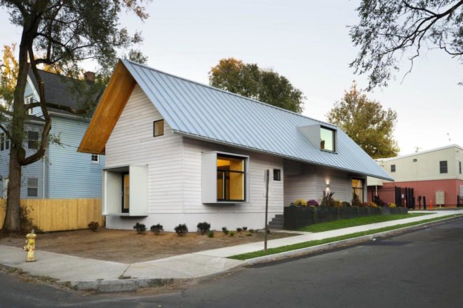 A white prefab home with sloping gray roofs