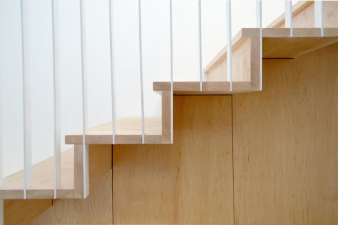 Close-up of wooden stairs with a white railing