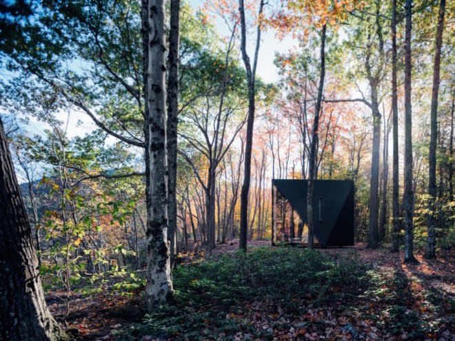 A triangular tiny house in the woods