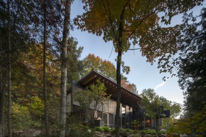Exterior of the home surrounded by forest