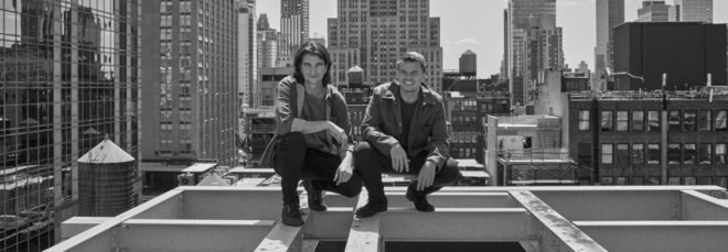 Bjarke Ingels and Adam Neumann in New York City on the frame of a building.