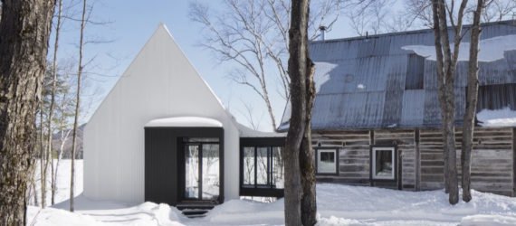 A rustic cabin and its modern white painted extension