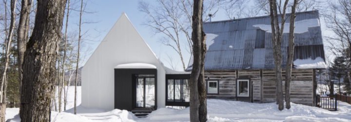 A rustic cabin and its modern white painted extension