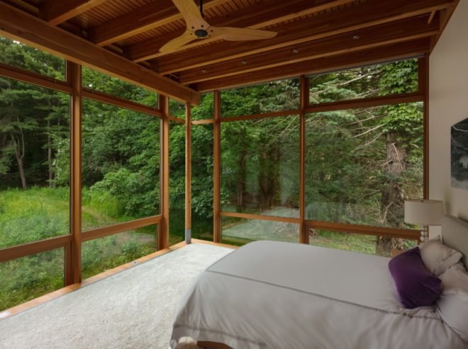 Bedroom with the bed facing the full-height windows