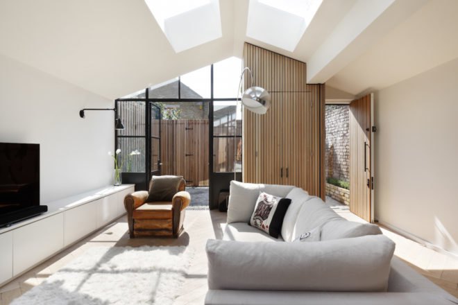 White couch, tan leather chairs, and a TV make up the living space