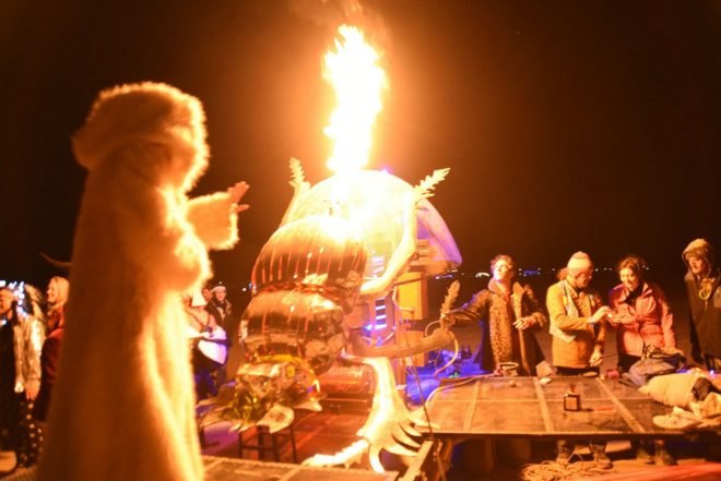 A metal dung beetle shooting flames into the air at night