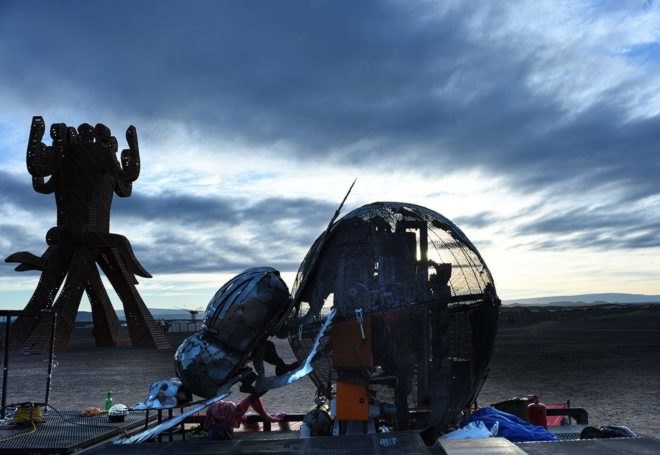 A metal dung beetle sculpture during the day