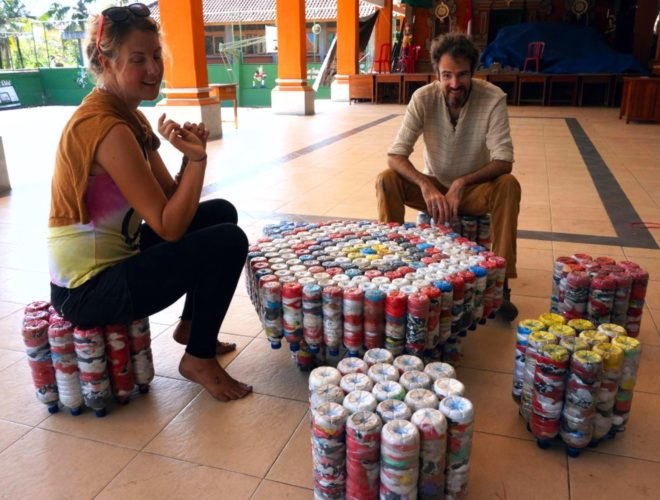 A man and a woman sit on furniture made out of ecobricks