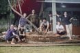 A group of people stands around a planter made with ecobricks