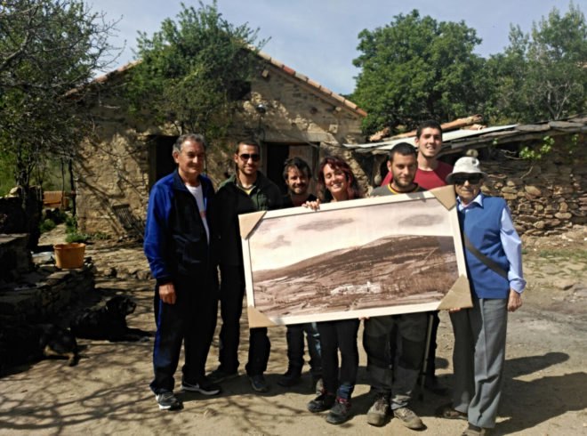 group of people holding an old photo