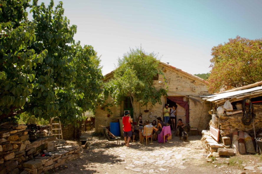 a group of people standing outside a stone home