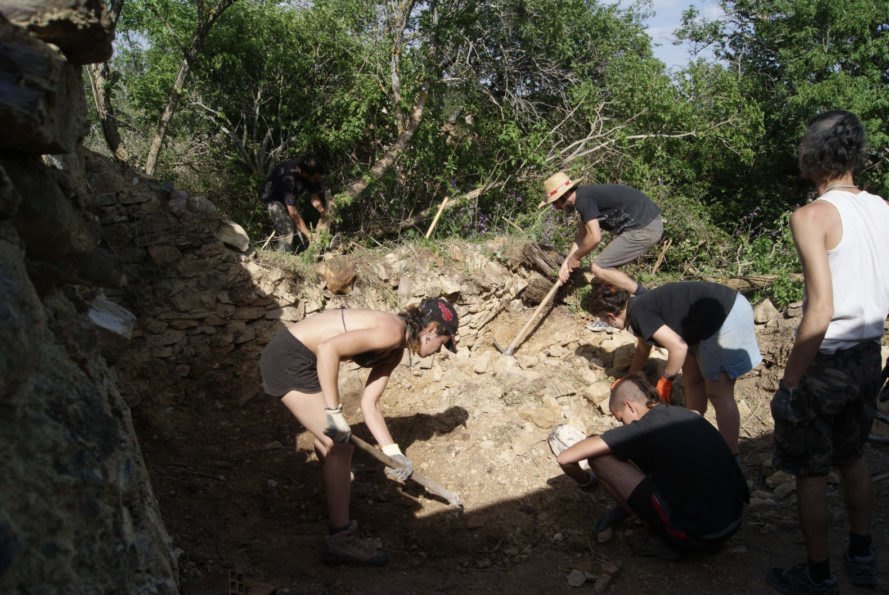 three people with shovels in the dirt