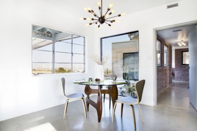 Dining room table and chairs with a unique chandelier above the table