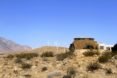 Home in the desert with wind turbines in the background