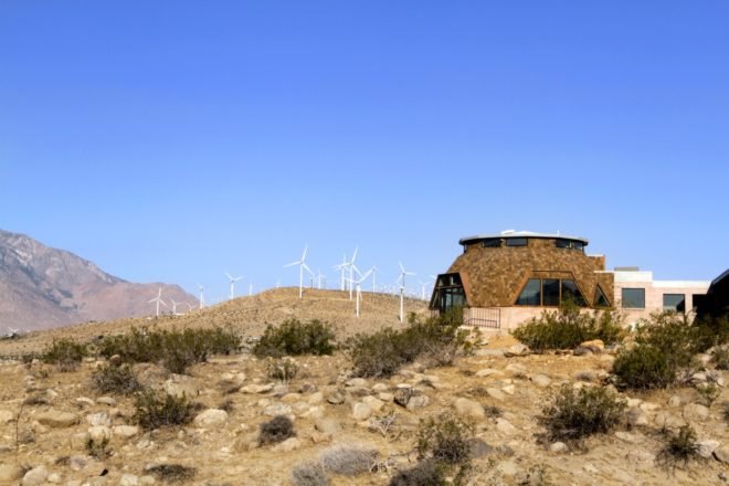 Home in the desert with wind turbines in the background