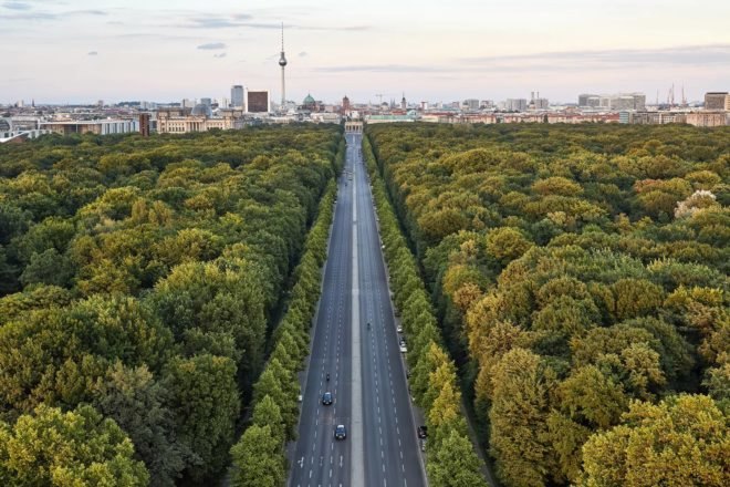 Highway between trees leading into the city of Berlin