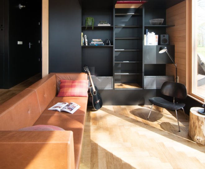long orange sofa and black wall
