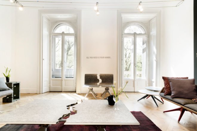 a living room with a chair and table that appear to have a divide in the midway point of each piece of furniture