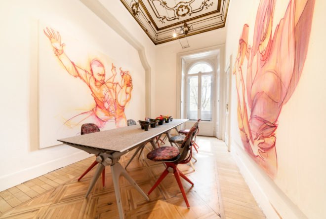 Room with a long table and large artwork on the walls