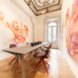 Room with a long table and large artwork on the walls