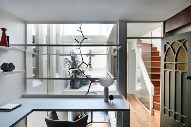 A modern home office space with a view of chairs and a living room.