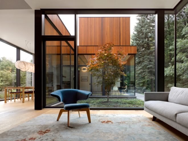 A blue chair in front of a floor to ceiling window