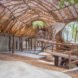 A curving interior space covered in branches and vines