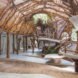 A curving interior space covered in branches and vines