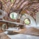 A curving interior space covered in branches and vines