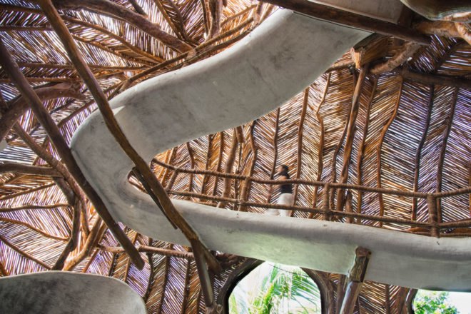 A curved concrete walkway beneath a room's curved ceiling
