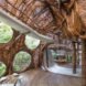 An interior space with round windows and walls made from branches