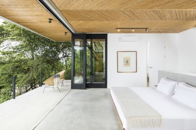 An open-air bedroom with a large white bed.