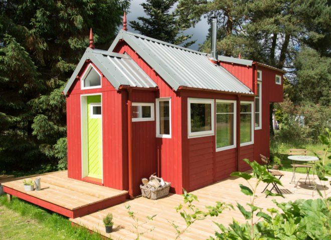 red tiny home with wooden deck