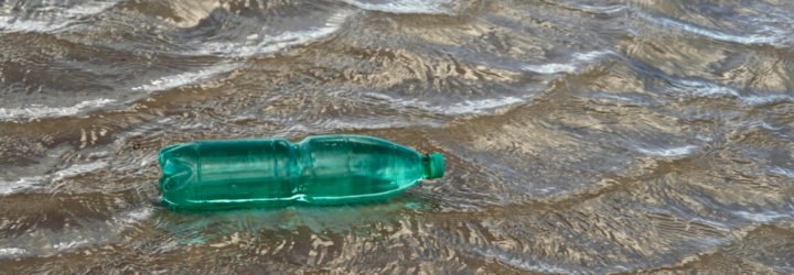 Green plastic bottle floating on water